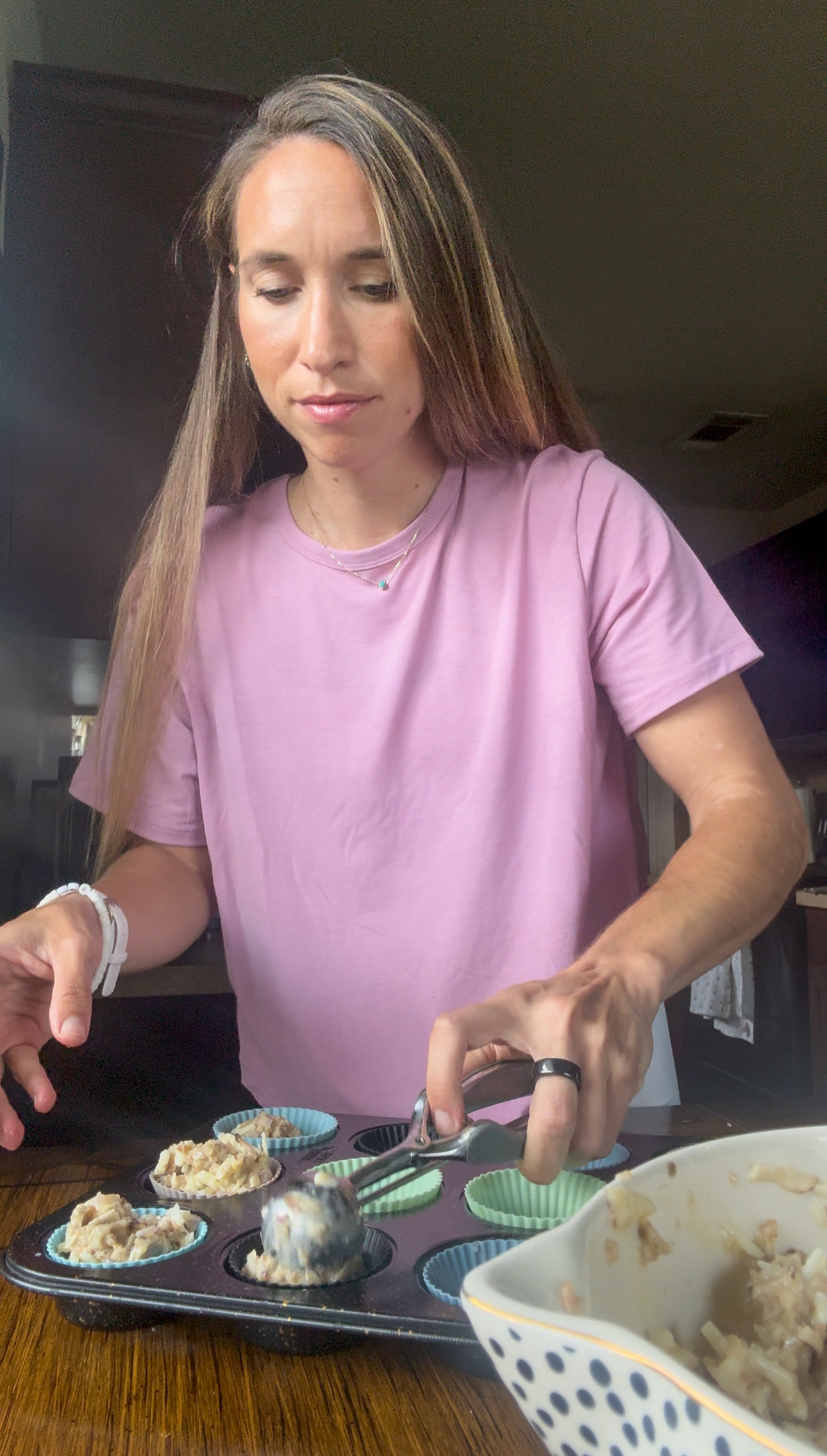 scooping muffin mix into muffin tin
