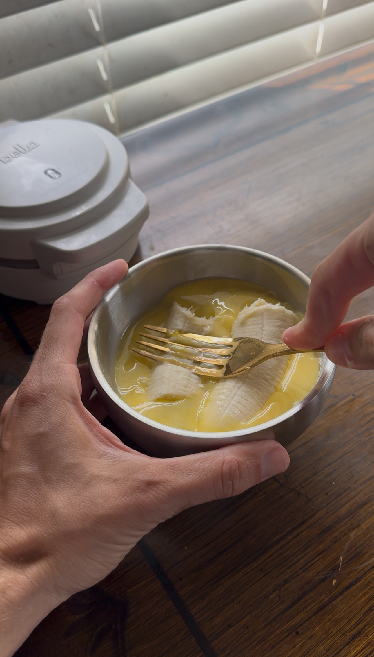 mashing the banana and egg together for the banana egg waffles