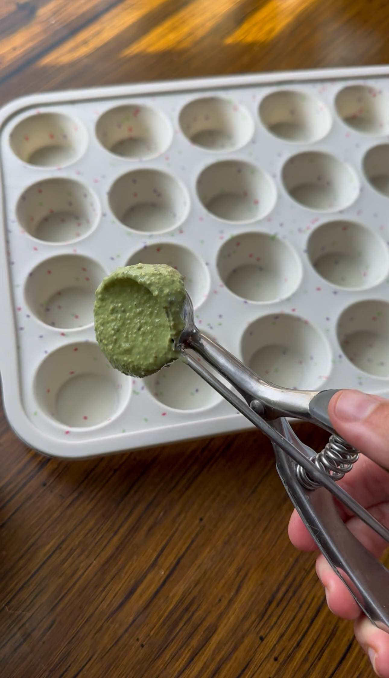adding the spinach oatmeal batter into the muffin tin