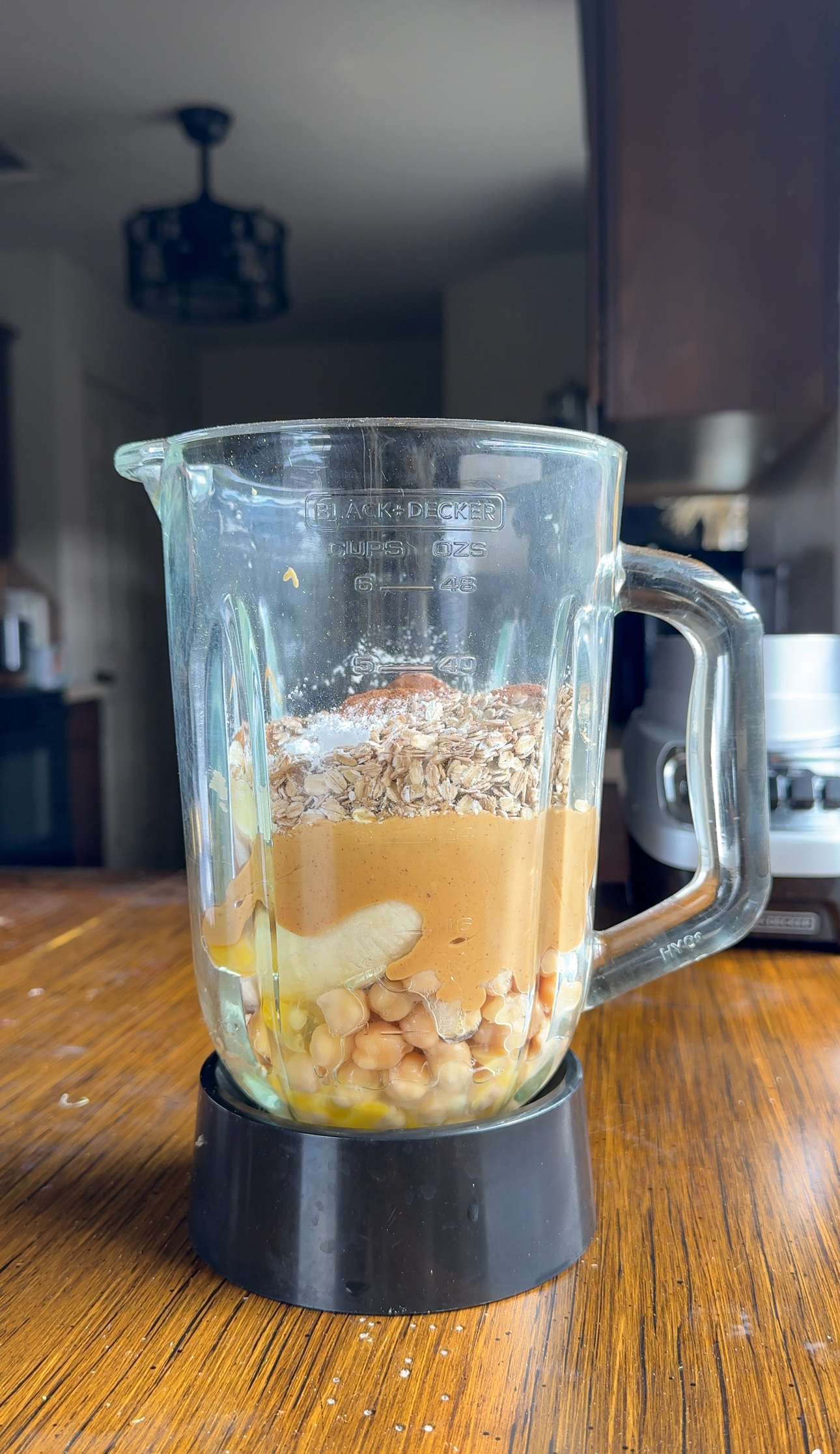 adding all the ingredients into the blender with banana, peanut butter, oats, chickpeas