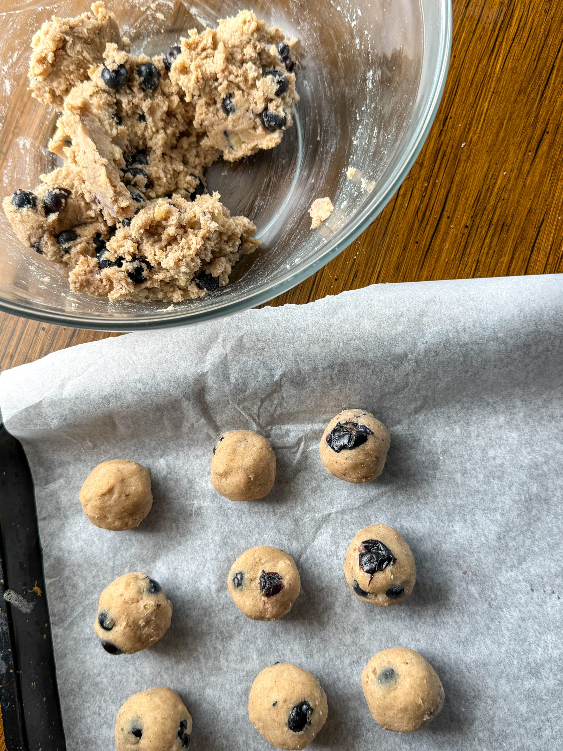 rolled blueberry banana donut holes being put in the oven