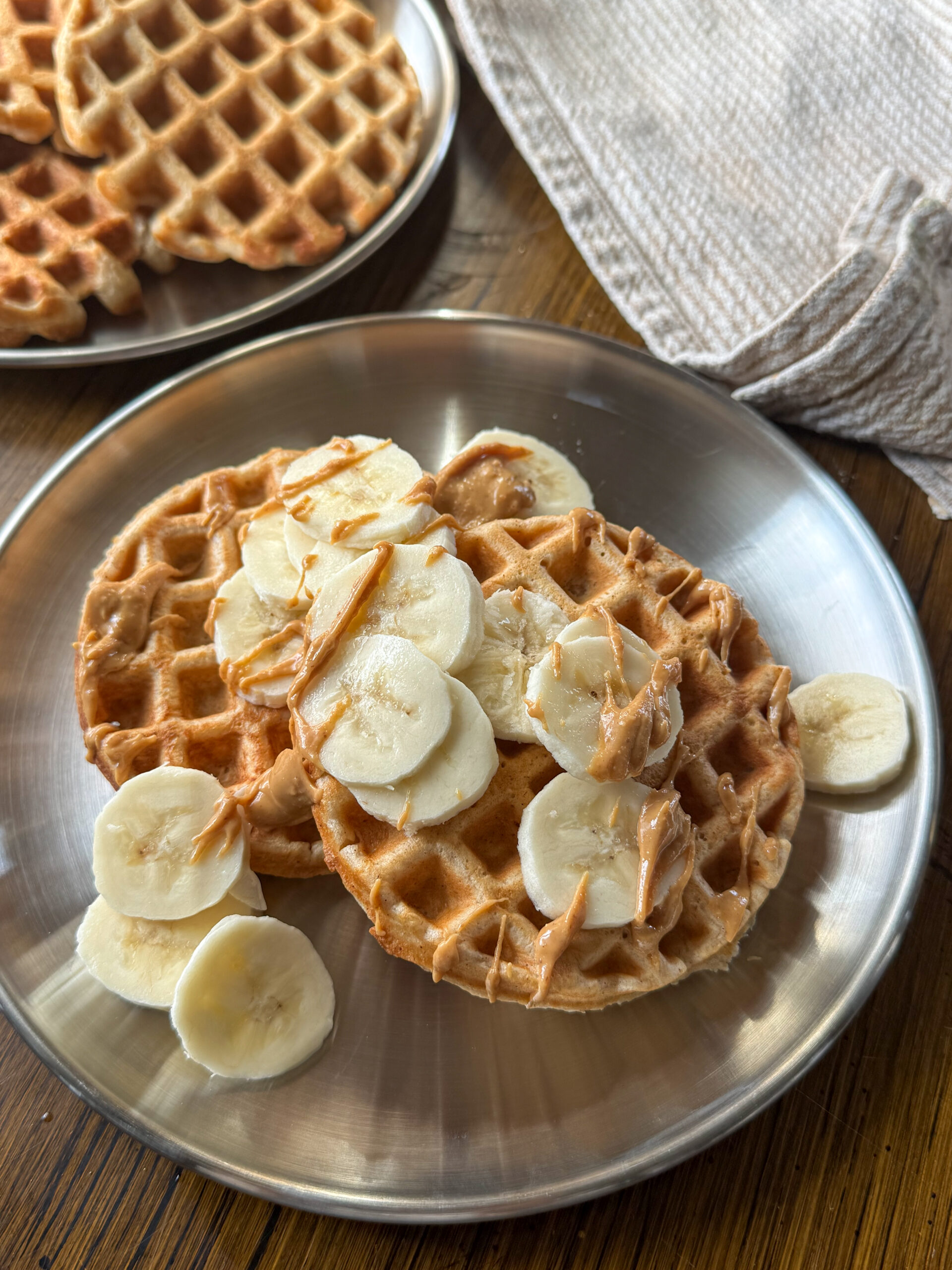 easy yogurt oat waffles with banana and peanut butter on top