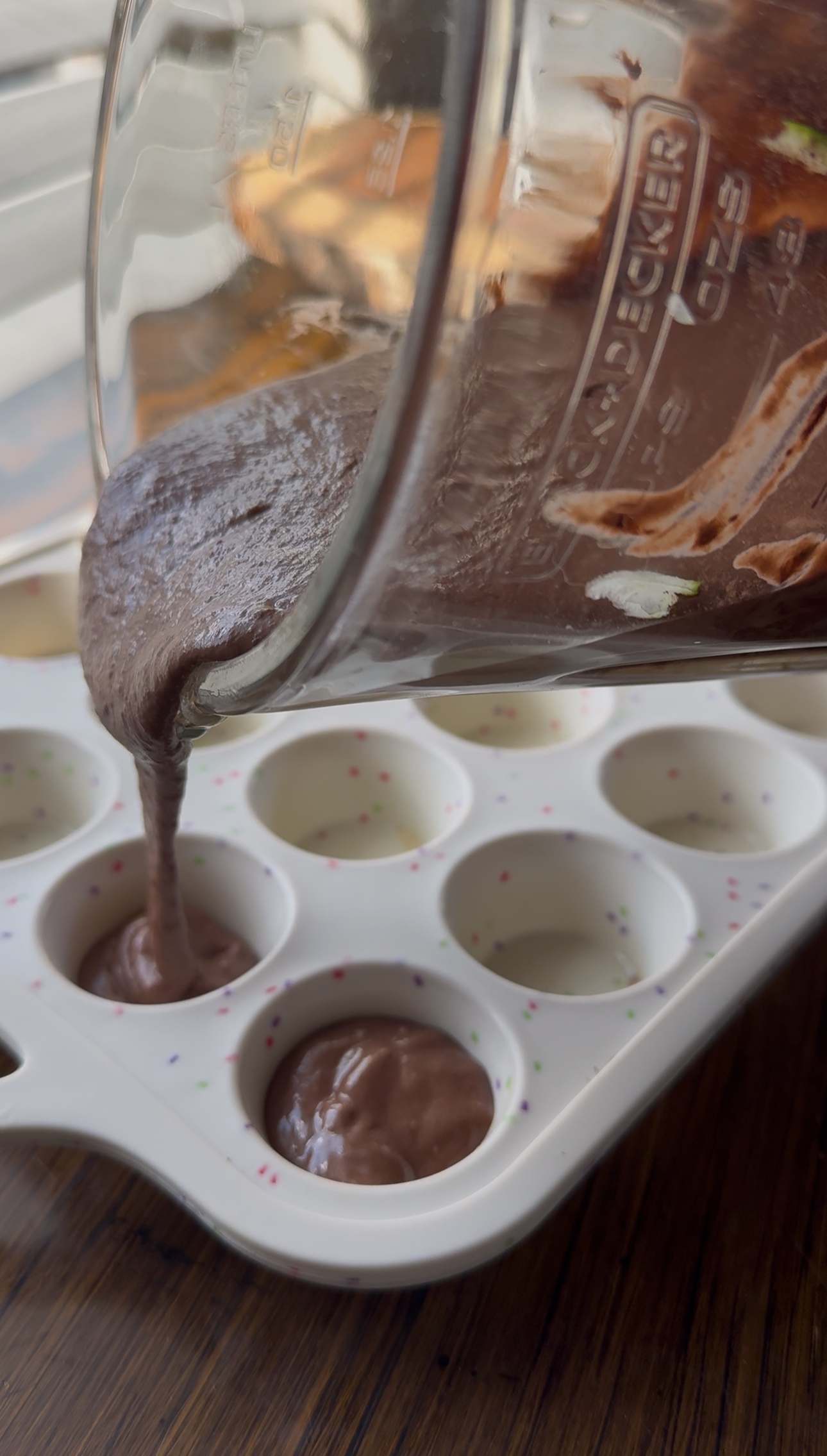pouring the brownie dough in the mini muffin pan
