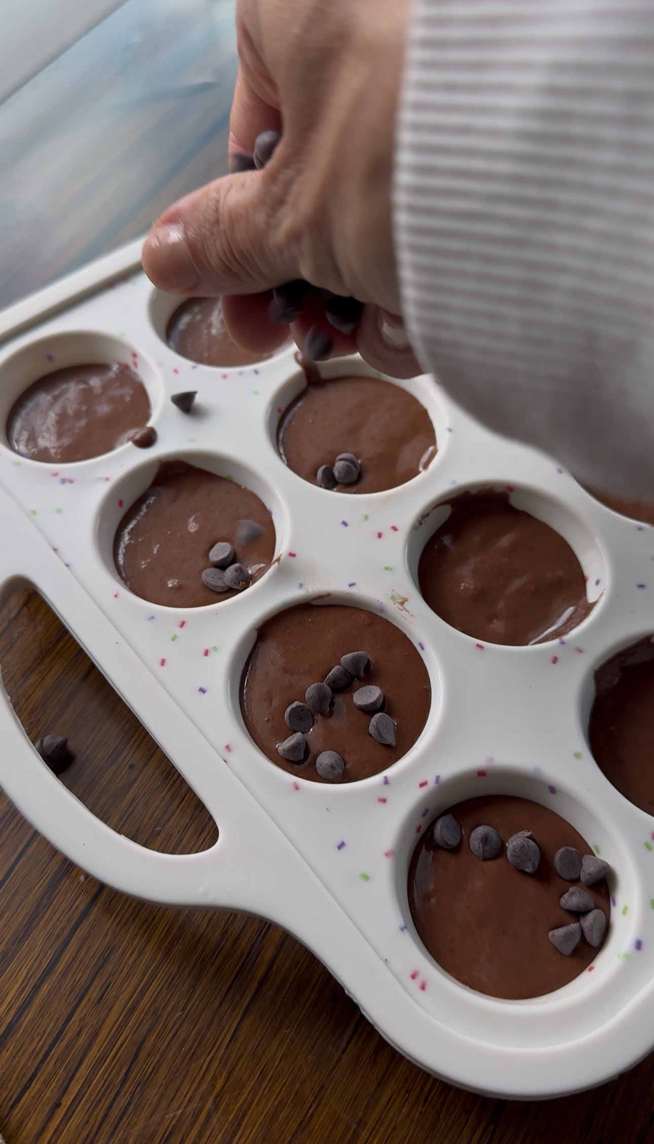 sprinkling mini chocolate chips on black bean brownie bites