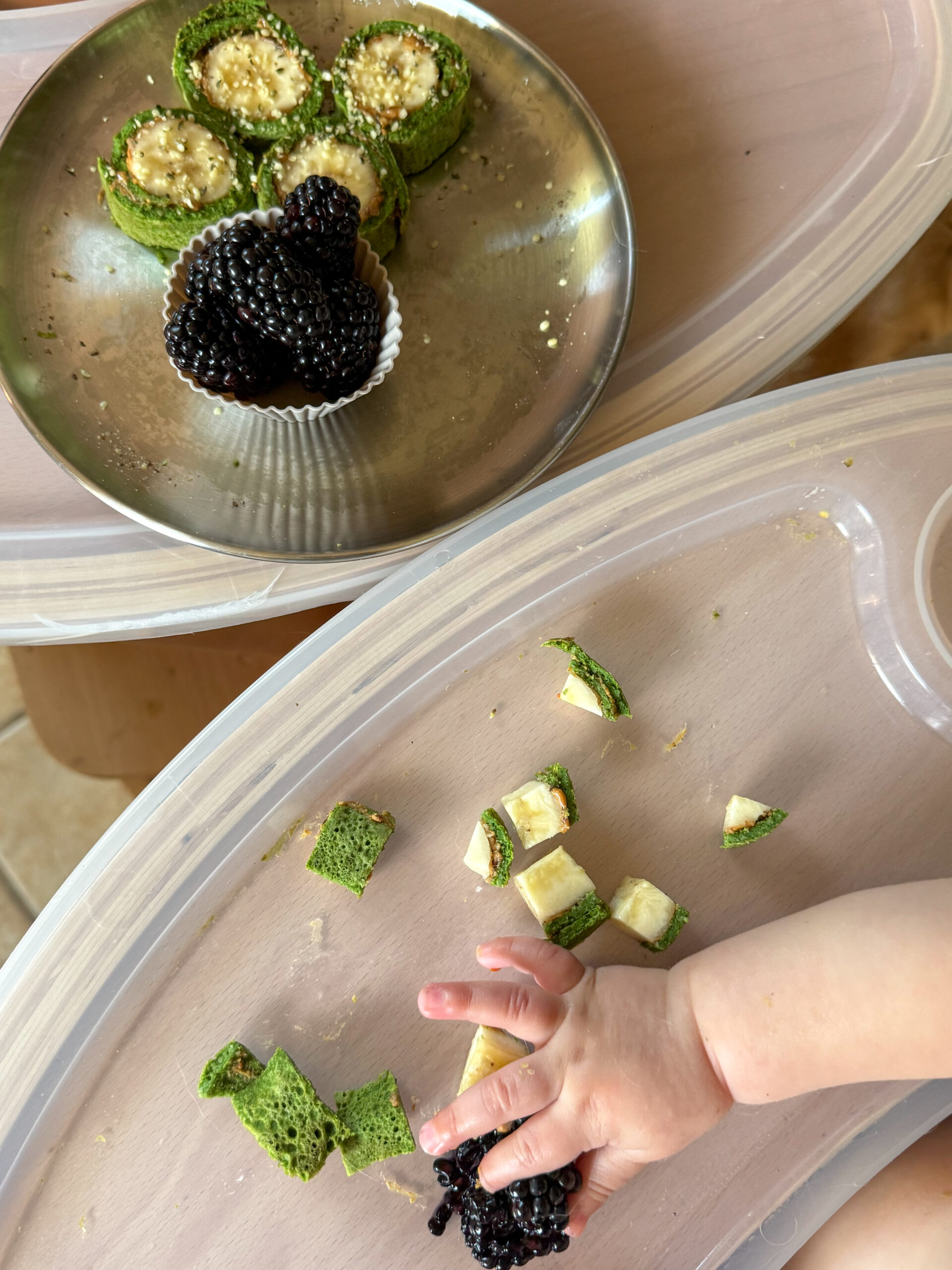 baby hand grabbing for a bite of the pinwheel