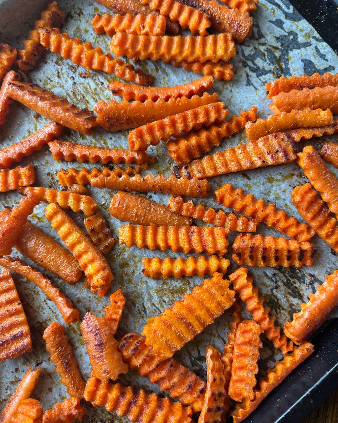 carrot fries laying on baking sheet