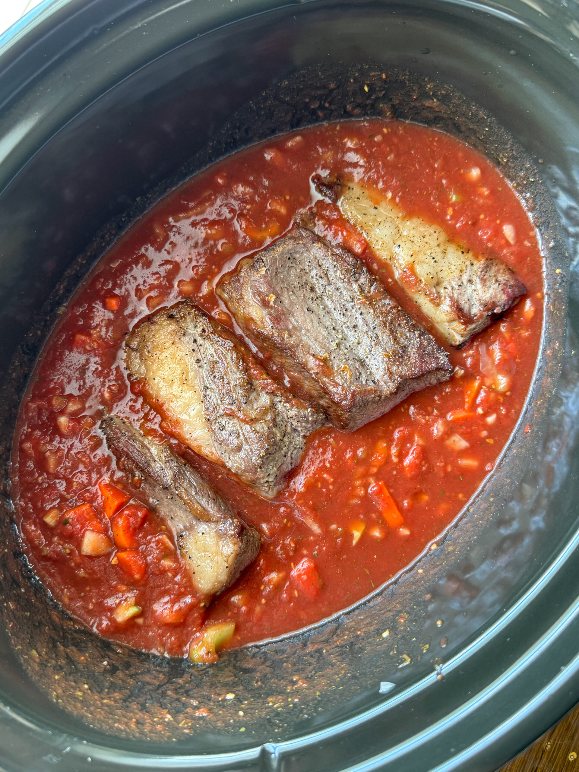 slow cooker beef short rib ragu nestled in tomato sauce