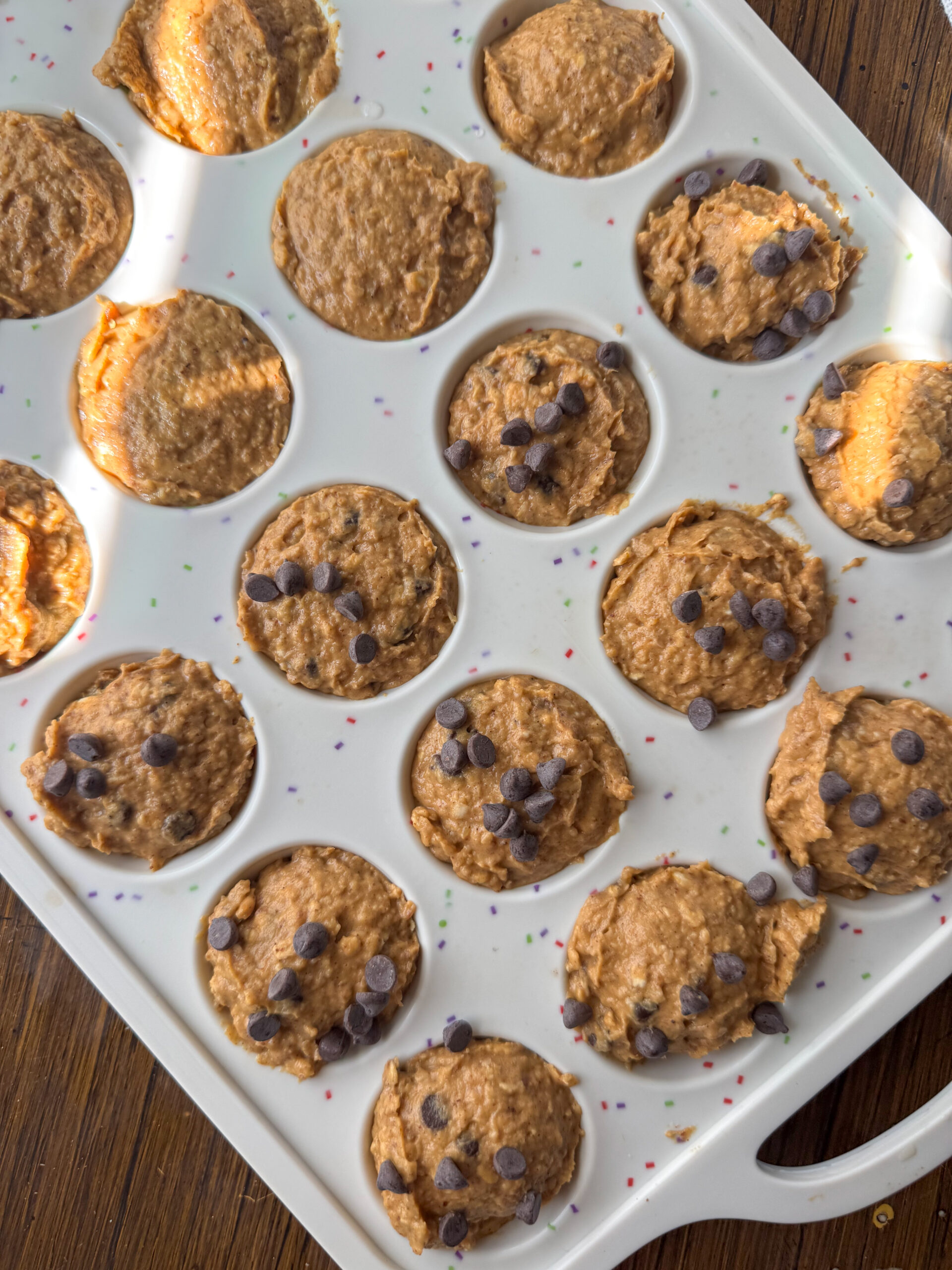 filling the muffin wells with batter