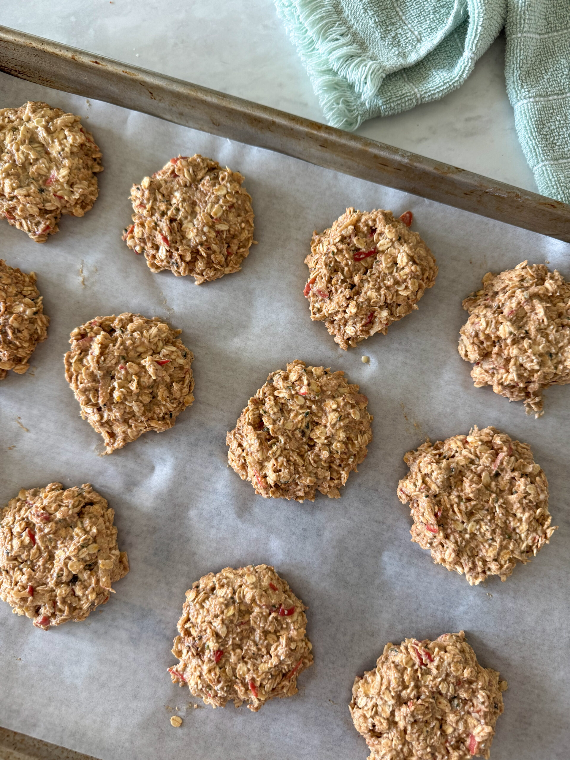 healthy apple cinnamon oatmeal cookies sitting on a baking sheet