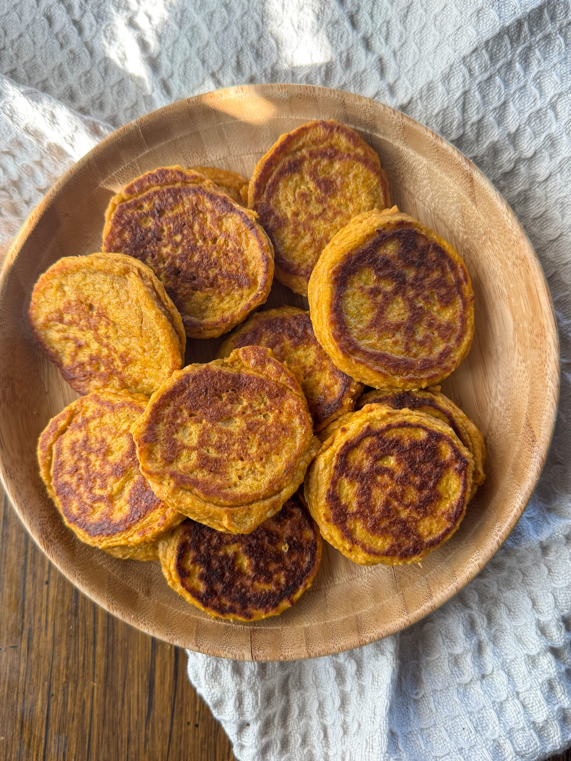 cooked sweet potato pancakes on a wooden plate