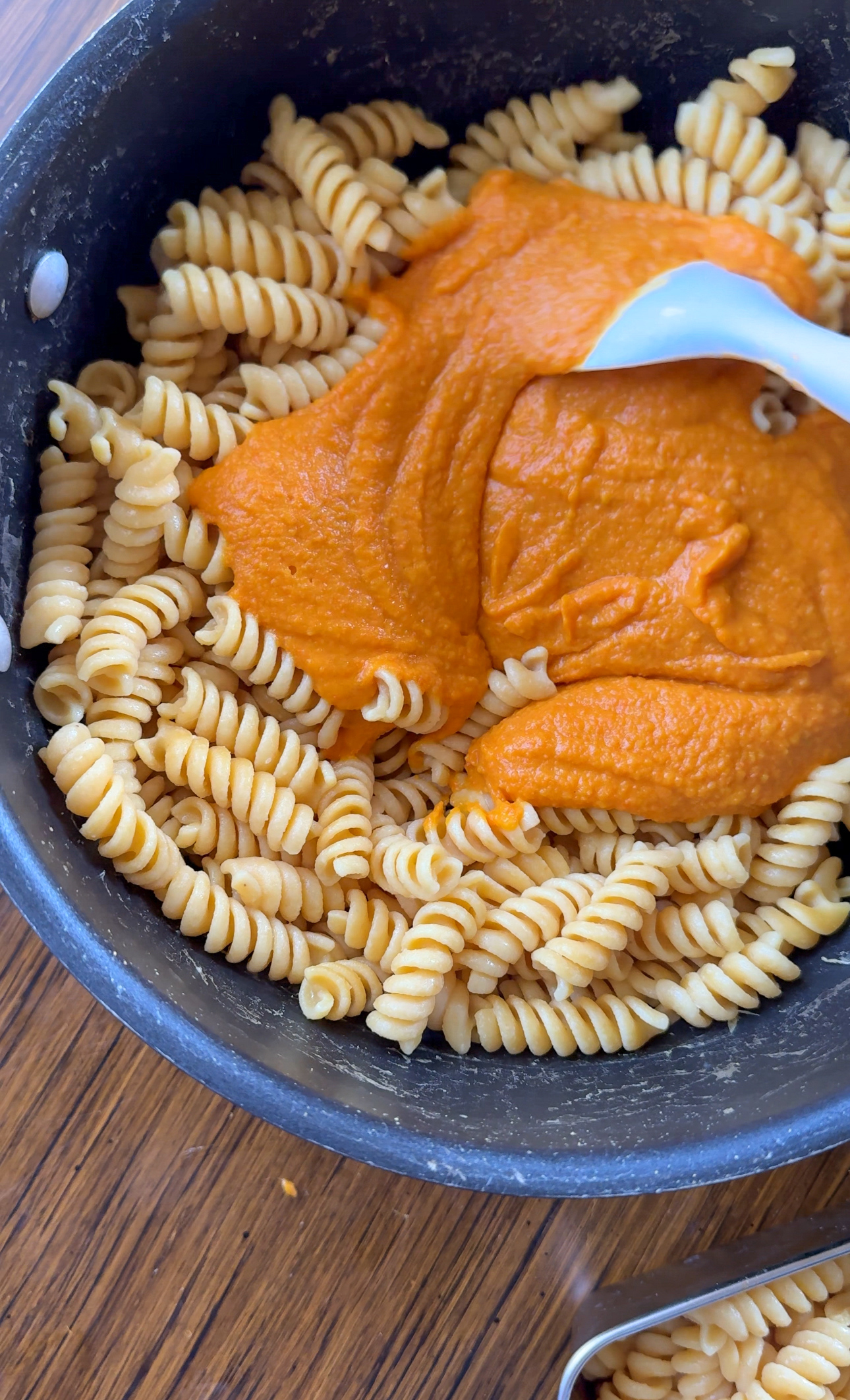 butternut squash pasta sauce being tossed with chickpea rotini noodles
