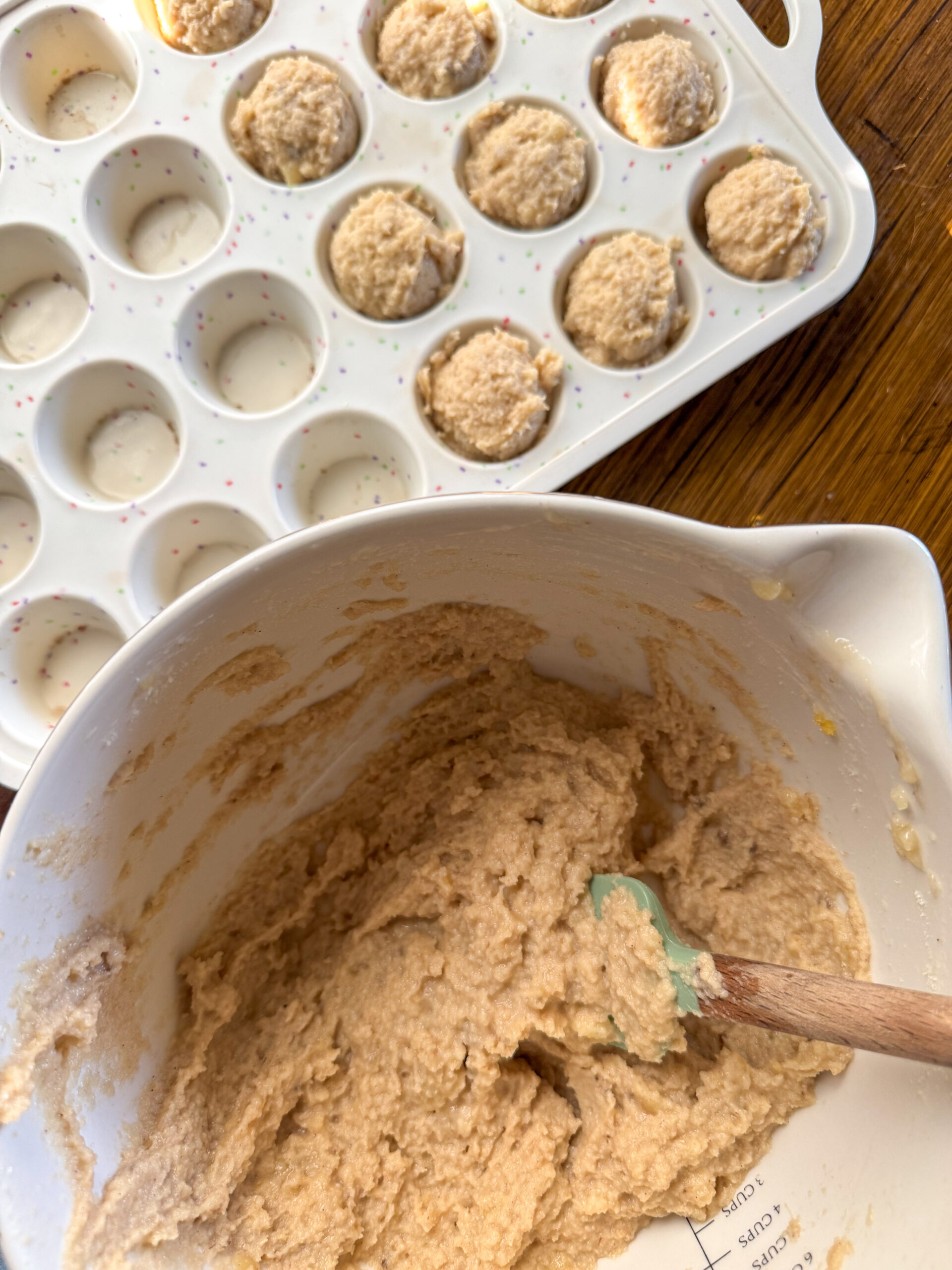 dividing the banana muffin batter into the muffin wells