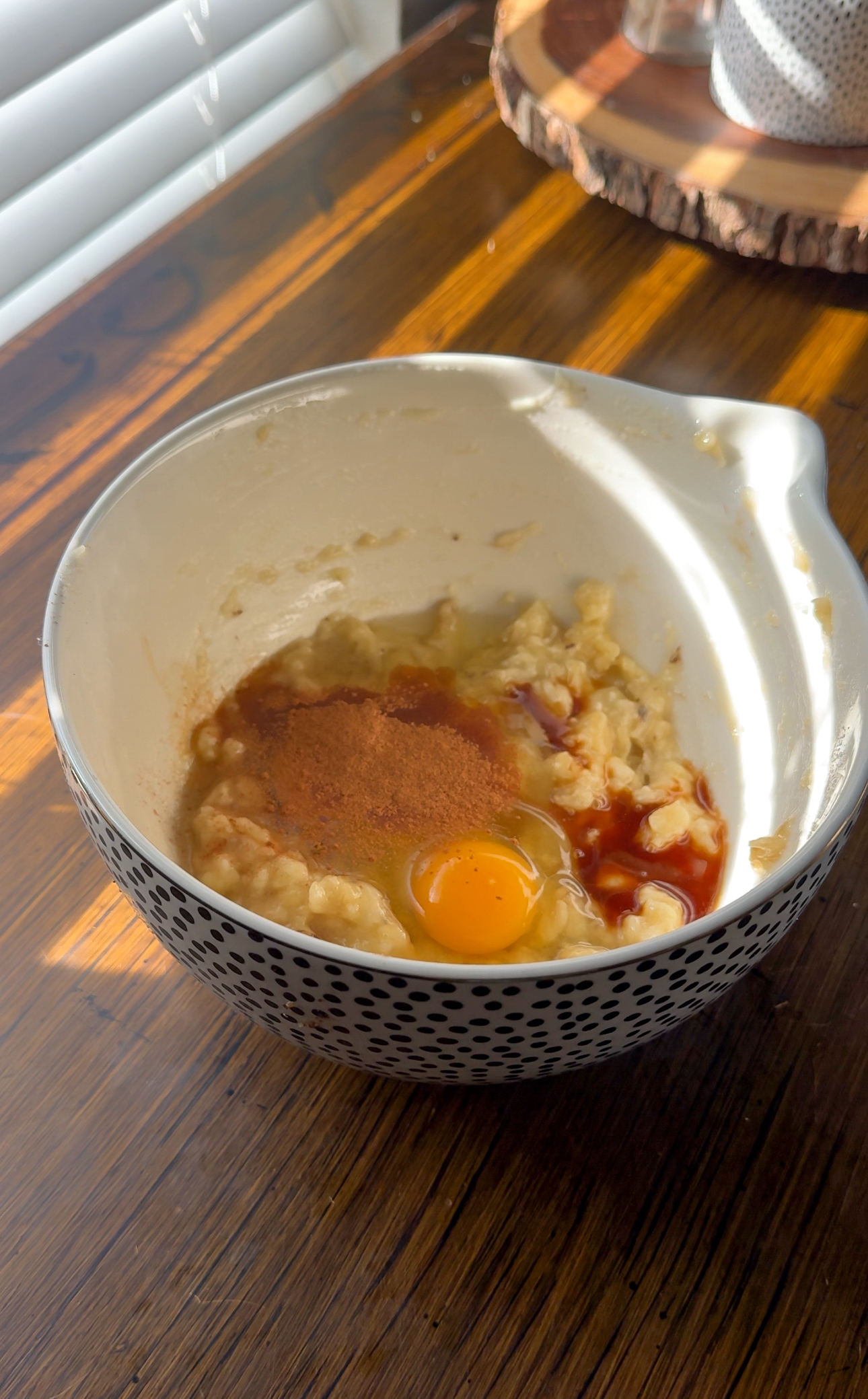 adding the bananas, eggs, cinnamon, and vanilla into a bowl for the banana muffins
