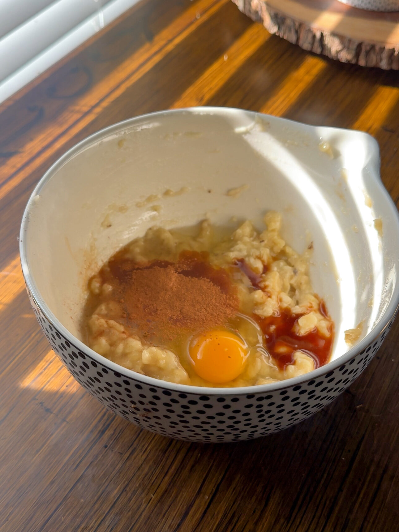 adding the bananas, eggs, cinnamon, and vanilla into a bowl for the banana muffins