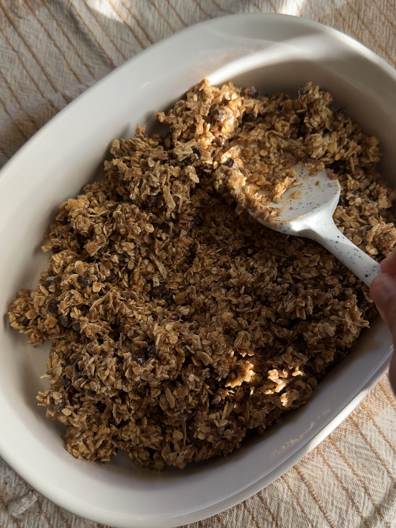 pressing the mixture down in a baking dish