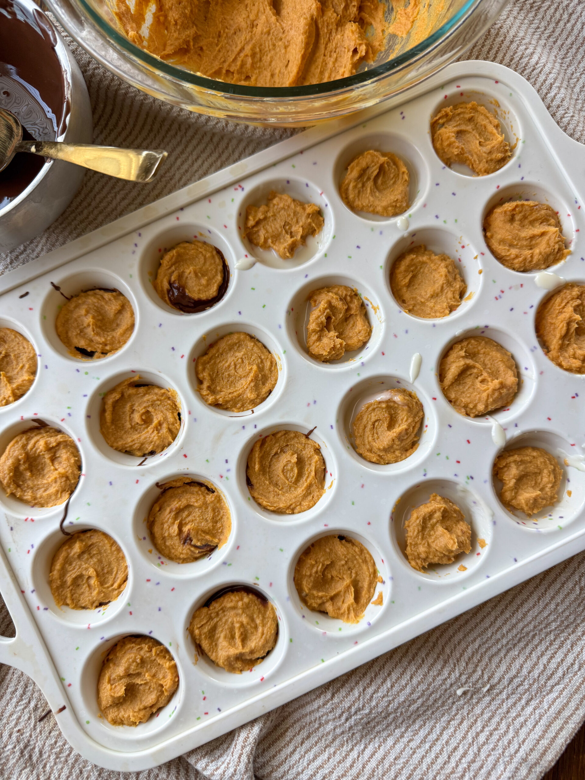 filling mini cups with peanut butter pumpkin filling