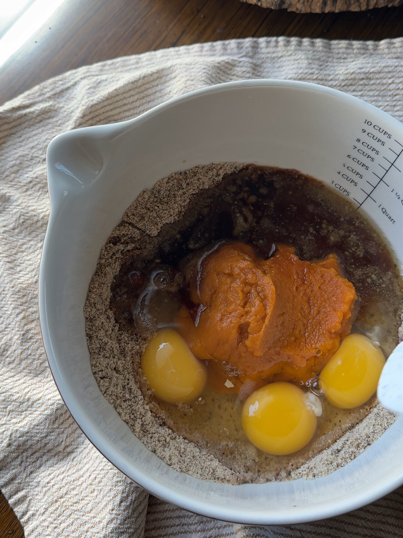 adding wet ingredients into the dry ingredients for pumpkin bread batter