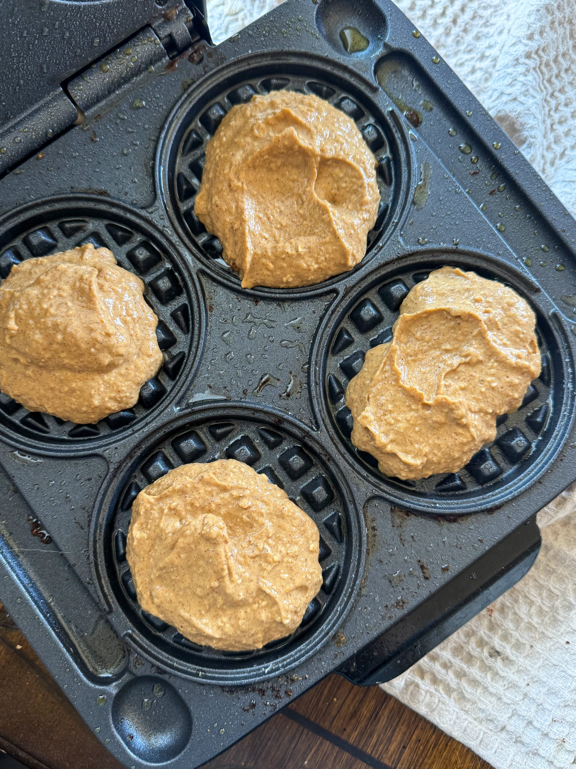 adding chickpea pumpkin waffle batter to the waffle iron