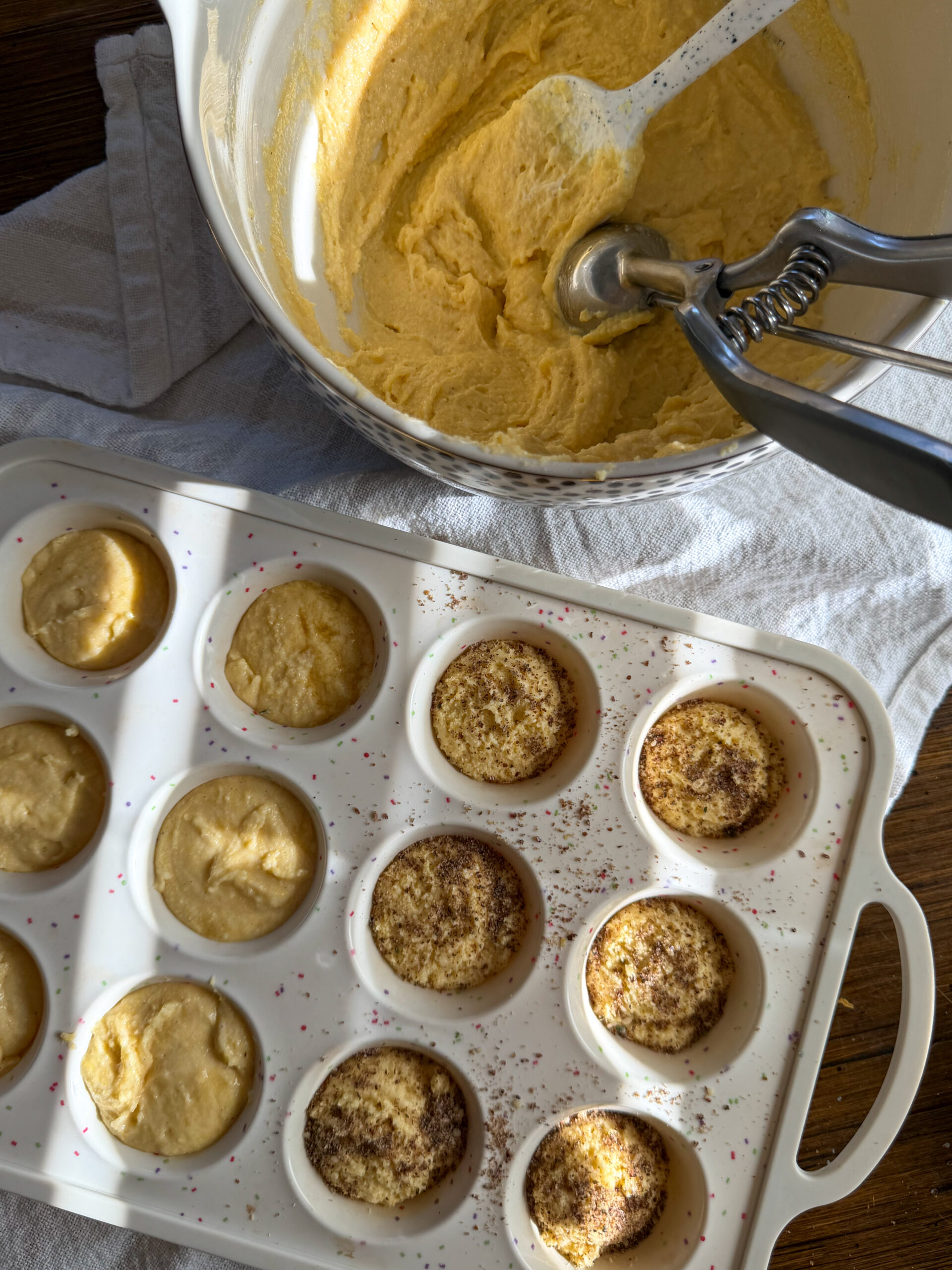 dividing greek yogurt cornbread muffin dough into muffin pan