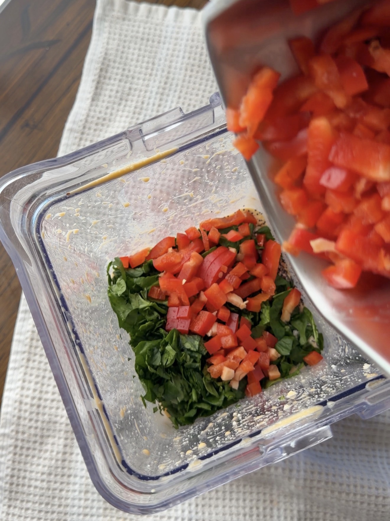 adding in the veggies and cheese to blender