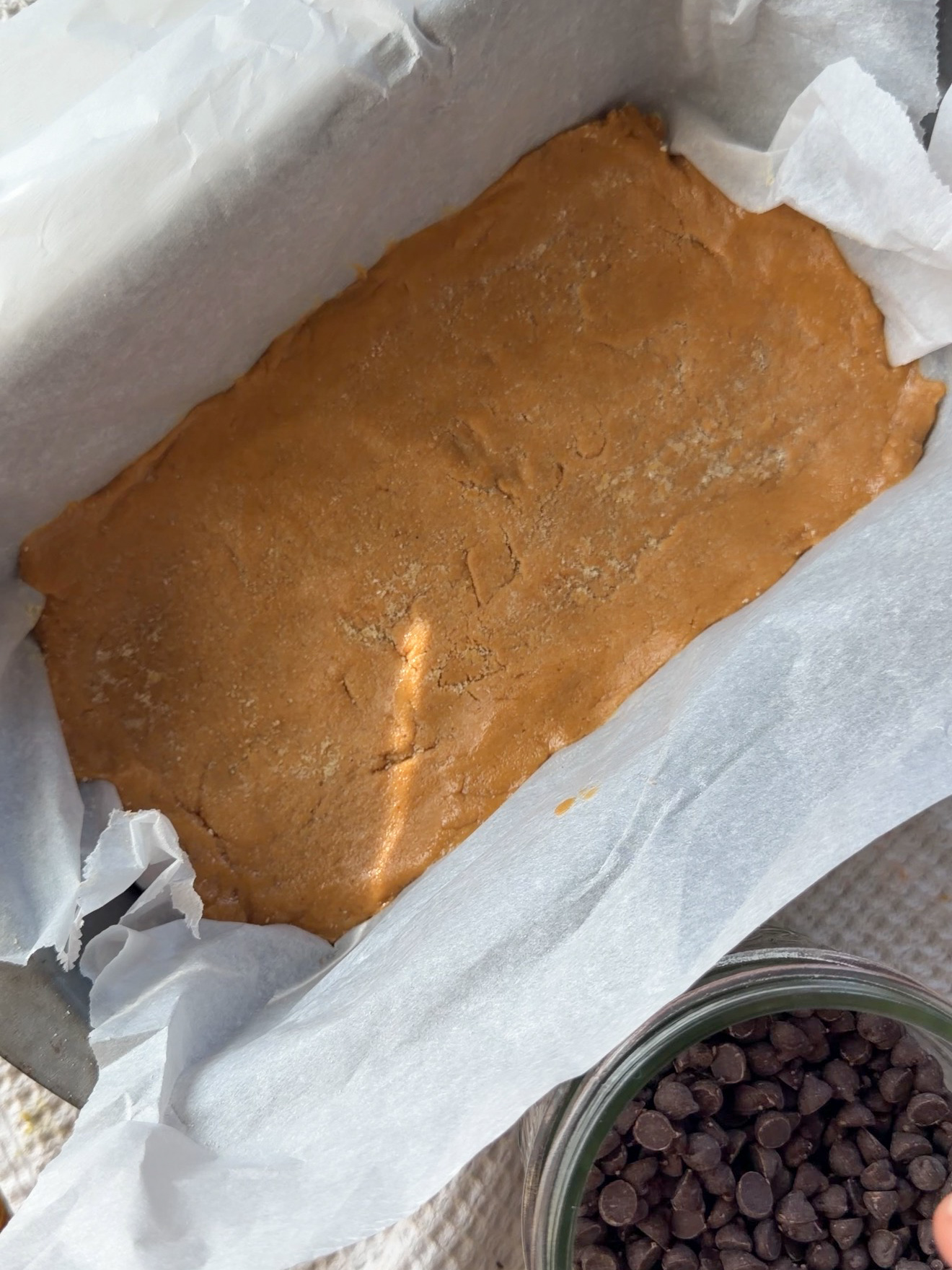 pressing peanut butter perfect bars copycat into a pan
