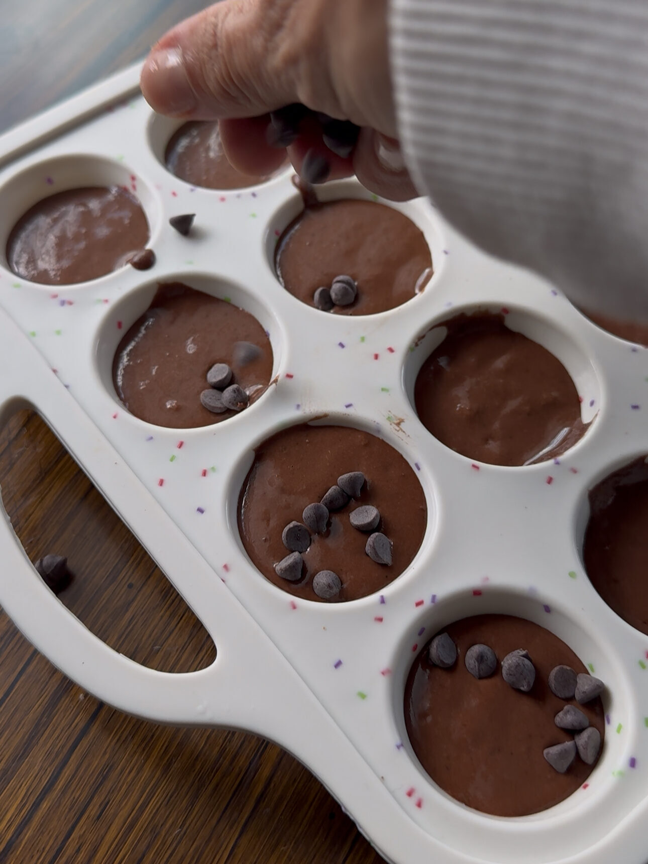 sprinkling mini chocolate chips on black bean brownie bites