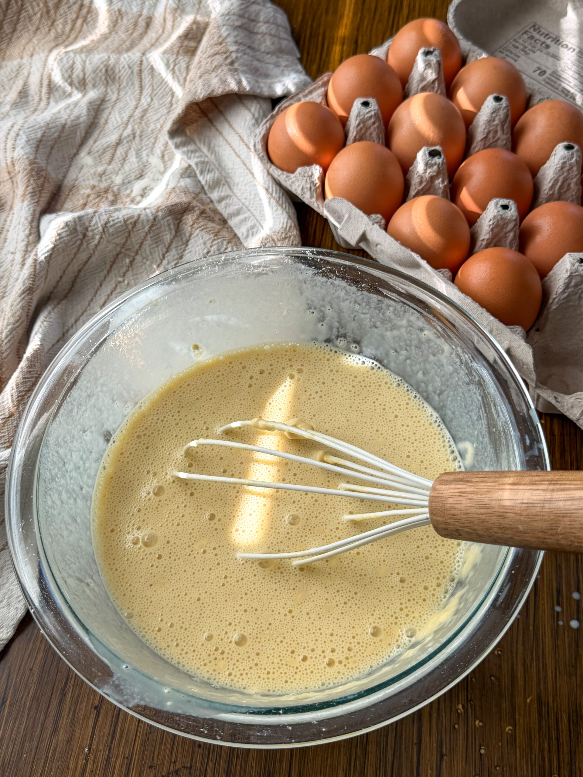 whisking crepe ingredients in a glass bowl