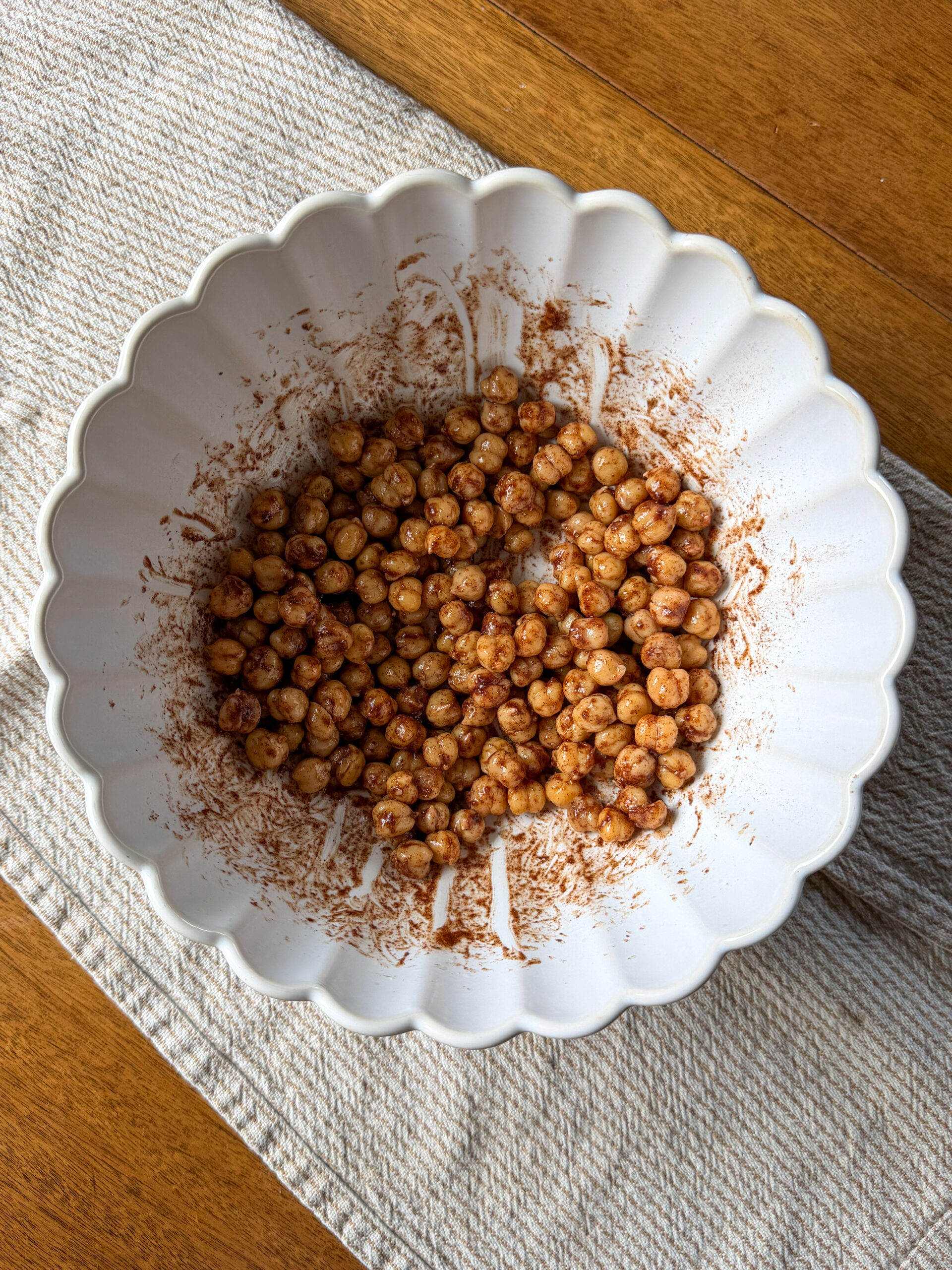 tossing the Easy Cinnamon Roasted Chickpeas (toddler-friendly protein snack) in cinnamon coating